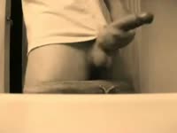 Endowed college aged stud wears only a t-shirt while modeling and stroking his large dick